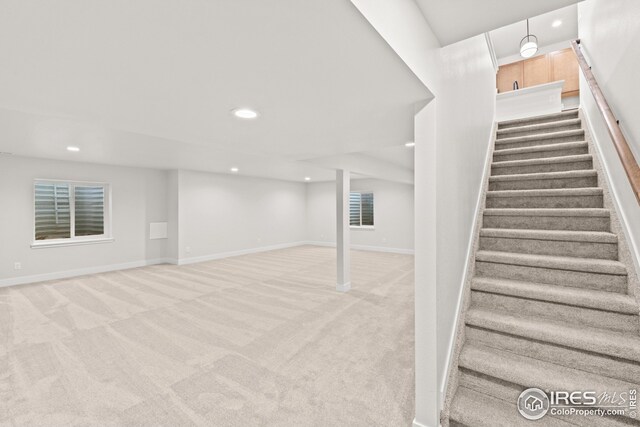 finished basement with light carpet, stairway, recessed lighting, and baseboards