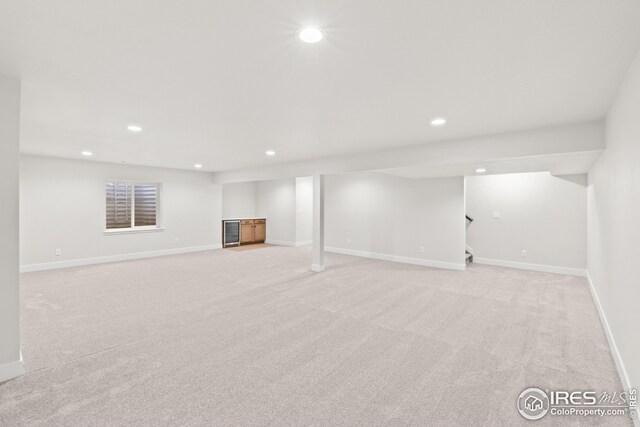 finished below grade area featuring stairway, recessed lighting, and light colored carpet