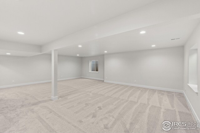 finished basement with recessed lighting, light colored carpet, and baseboards