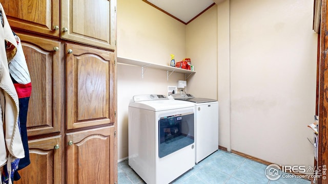 laundry room featuring separate washer and dryer, baseboards, ornamental molding, and cabinet space