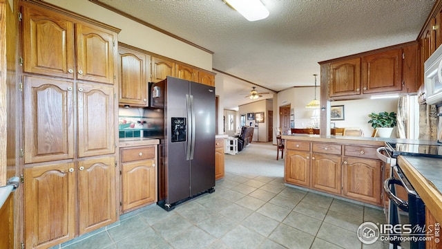 kitchen featuring light colored carpet, brown cabinets, a ceiling fan, and stainless steel appliances