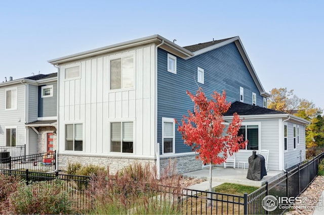 exterior space featuring stone siding, fence private yard, and a patio