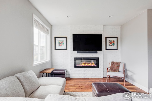 living room with recessed lighting, baseboards, wood finished floors, and a fireplace