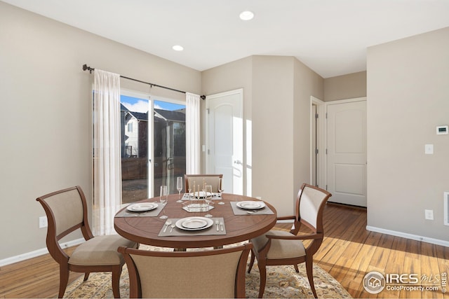 dining space with light wood finished floors, baseboards, and visible vents