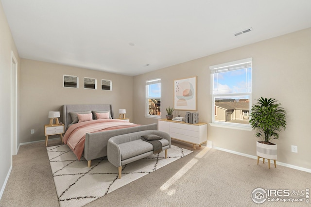 carpeted bedroom with baseboards and visible vents