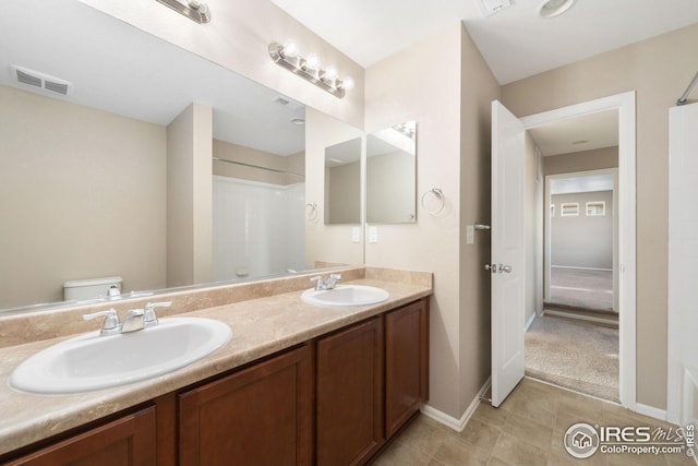 full bathroom with walk in shower, visible vents, a sink, and toilet