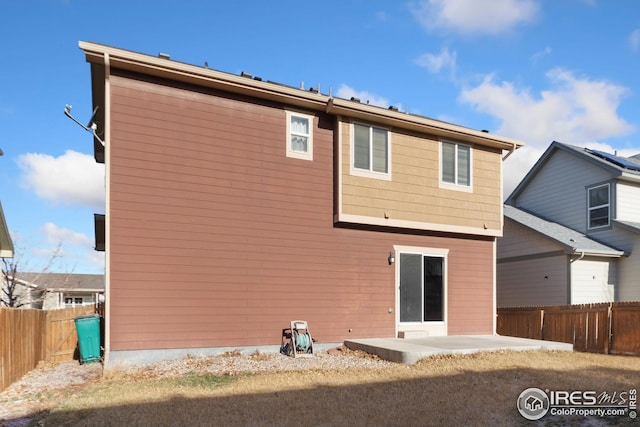 rear view of property featuring a patio area and a fenced backyard