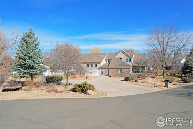 view of front of home featuring concrete driveway and fence