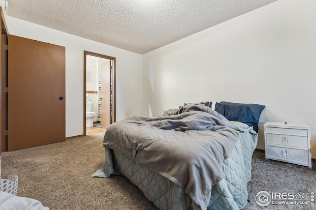 carpeted bedroom featuring ensuite bath and a textured ceiling