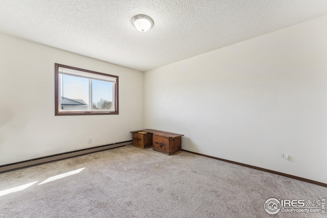 carpeted empty room with a textured ceiling, baseboards, and a baseboard radiator