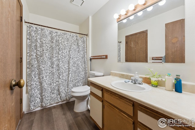 full bath with vanity, toilet, wood finished floors, and visible vents