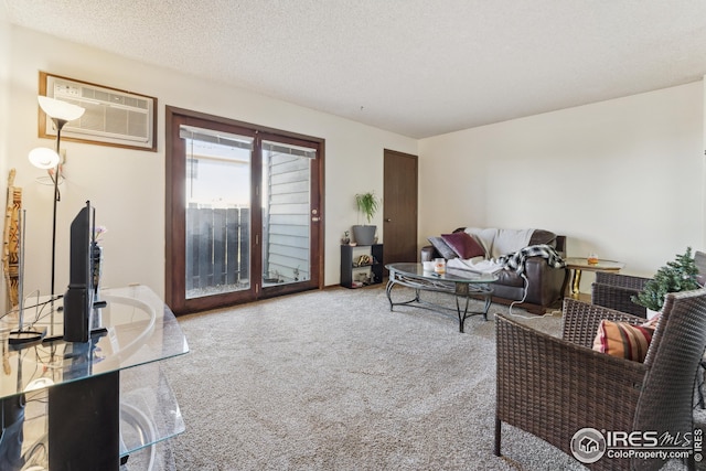 carpeted living room featuring a textured ceiling and a wall mounted AC
