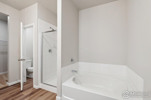 952 Cascade Falls St, Severance, CO 80550 - full bath with a stall shower, a garden tub, and wood finished floors