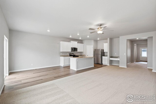 952 Cascade Falls St, Severance, CO 80550 - kitchen with appliances with stainless steel finishes, open floor plan, recessed lighting, ceiling fan, and white cabinetry