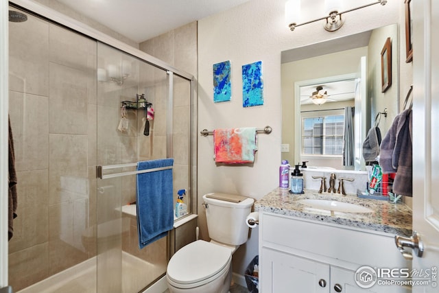 4216 Yellowbells Dr, Evans, CO 80620 - bathroom with toilet, vanity, a shower stall, and ceiling fan