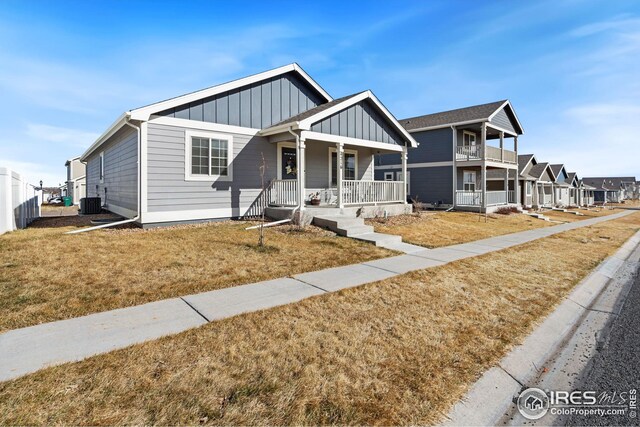 4216 Yellowbells Dr, Evans, CO 80620 - view of front of property featuring board and batten siding, covered porch, central AC unit, and a front lawn