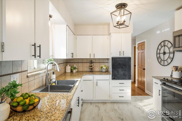 169 Emerald St, Broomfield, CO 80020 - kitchen with an inviting chandelier, a sink, white cabinets, stainless steel appliances, and tasteful backsplash