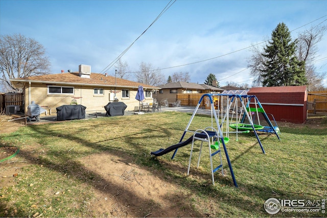 169 Emerald St, Broomfield, CO 80020 - back of property featuring a lawn, an outdoor structure, a playground, a fenced backyard, and a storage unit