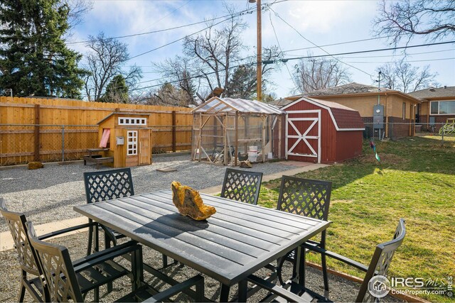 169 Emerald St, Broomfield, CO 80020 - view of patio / terrace featuring a fenced backyard, a storage shed, outdoor dining space, and an outbuilding