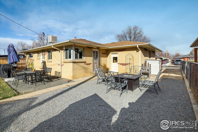 169 Emerald St, Broomfield, CO 80020 - back of property featuring a patio area, an outdoor fire pit, fence, and brick siding