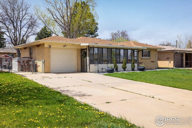 169 Emerald St, Broomfield, CO 80020 - ranch-style home with a gate, an attached garage, brick siding, concrete driveway, and a front yard
