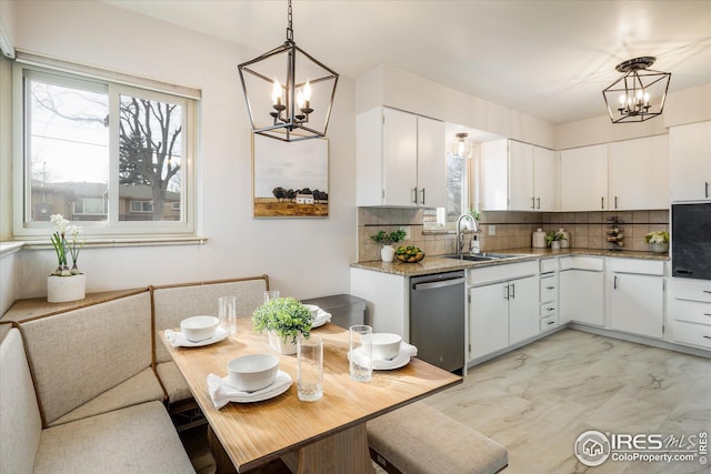169 Emerald St, Broomfield, CO 80020 - kitchen with decorative backsplash, stainless steel dishwasher, a sink, and a notable chandelier