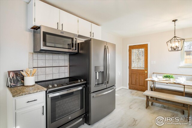 169 Emerald St, Broomfield, CO 80020 - kitchen featuring marble finish floor, a chandelier, backsplash, stainless steel appliances, and white cabinets