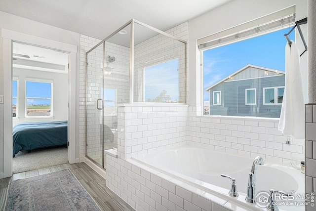 bathroom featuring a garden tub, wood finished floors, a stall shower, and connected bathroom