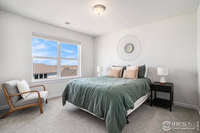 carpeted bedroom featuring baseboards and visible vents