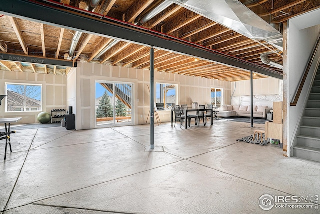 basement with a healthy amount of sunlight and stairs