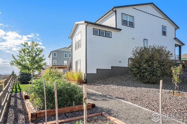 view of side of property featuring a garden and fence