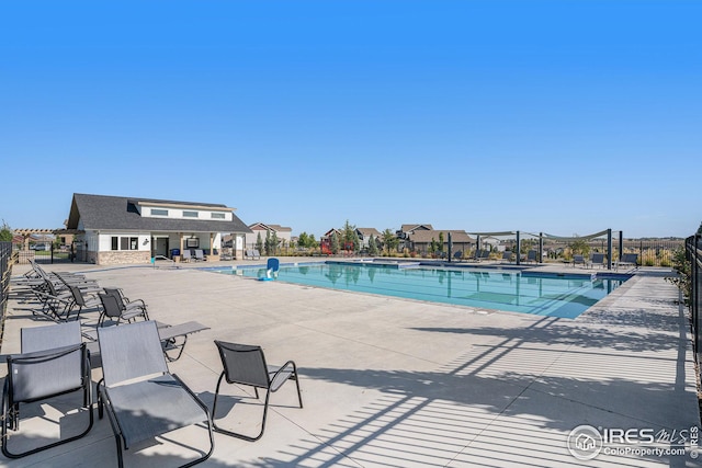 community pool featuring a patio and fence