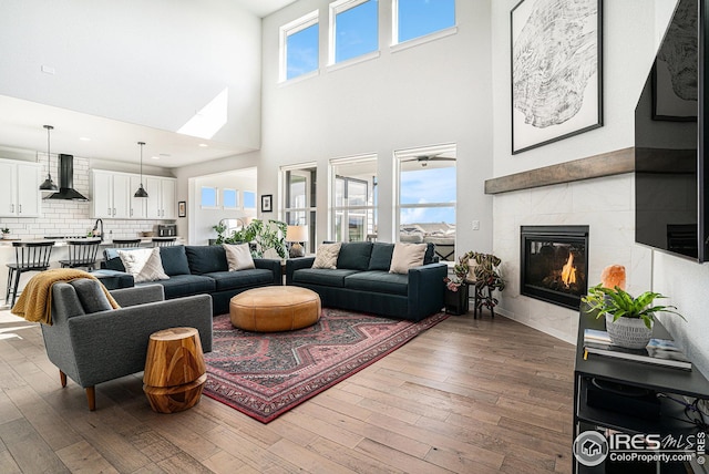 living room with wood finished floors and a tile fireplace