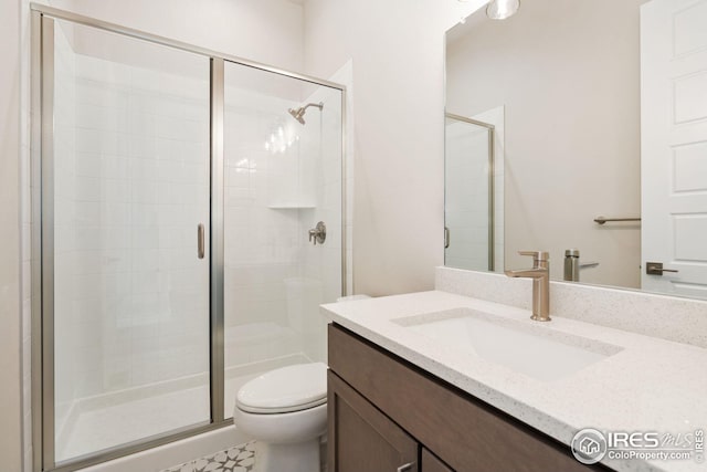 full bathroom featuring toilet, a stall shower, and vanity