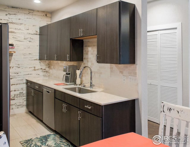 kitchen with dark brown cabinetry, appliances with stainless steel finishes, light countertops, and a sink