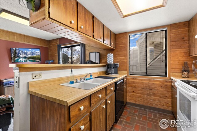 kitchen featuring a sink, white range with electric stovetop, wooden walls, brick floor, and dishwasher
