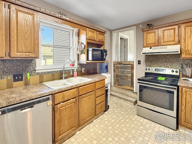 105 N Logan Ave, Haxtun, CO 80731 - kitchen featuring stainless steel appliances, under cabinet range hood, a sink, light countertops, and backsplash