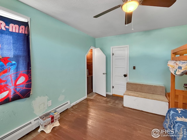 105 N Logan Ave, Haxtun, CO 80731 - bedroom with hardwood / wood-style flooring, a baseboard radiator, baseboards, and ceiling fan