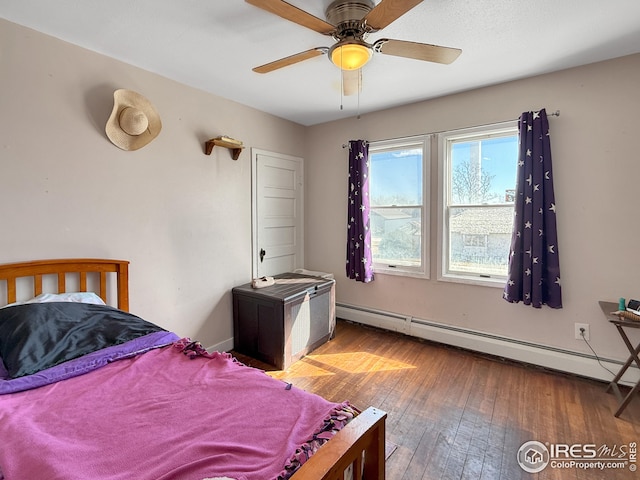 105 N Logan Ave, Haxtun, CO 80731 - bedroom with a baseboard heating unit, hardwood / wood-style floors, and ceiling fan