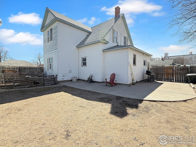 105 N Logan Ave, Haxtun, CO 80731 - back of property featuring a patio, a chimney, a fenced backyard, and roof with shingles