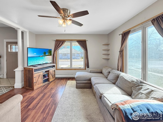 105 N Logan Ave, Haxtun, CO 80731 - living area with a baseboard heating unit, wood finished floors, decorative columns, and a ceiling fan