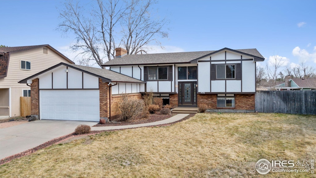 view of front facade with driveway, brick siding, an attached garage, and fence