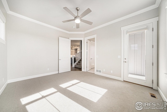 unfurnished bedroom with carpet floors, crown molding, visible vents, and baseboards