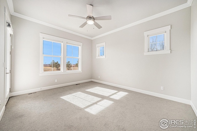 empty room with a ceiling fan, baseboards, crown molding, and carpet