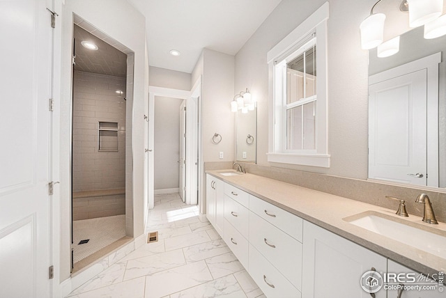 bathroom with marble finish floor, a sink, recessed lighting, and tiled shower