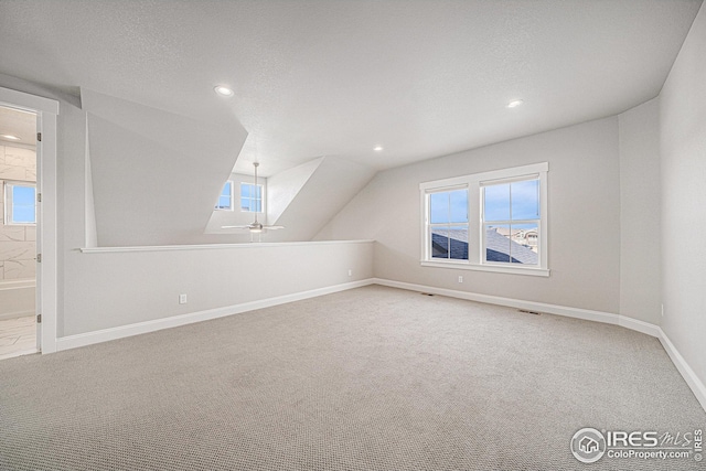additional living space with vaulted ceiling, carpet, baseboards, visible vents, and recessed lighting