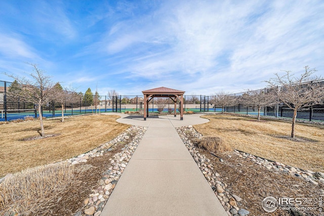 view of jungle gym featuring a gazebo, a tennis court, and fence