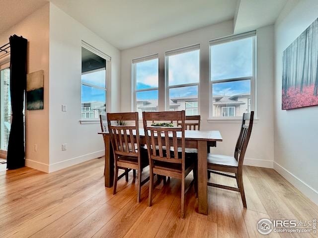 dining area with baseboards, a healthy amount of sunlight, and light wood-type flooring