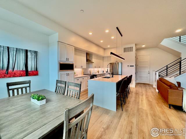 dining space with visible vents, recessed lighting, and light wood finished floors