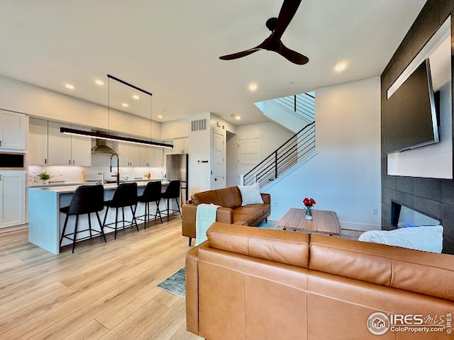 living area with visible vents, light wood finished floors, stairs, ceiling fan, and recessed lighting